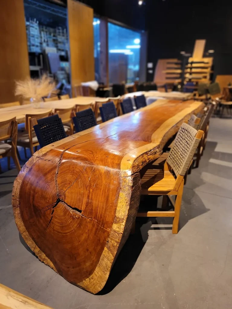 Mesa cascata de madeira avermelhada com lateral curva mostrando os anéis do tronco, em Curitiba
