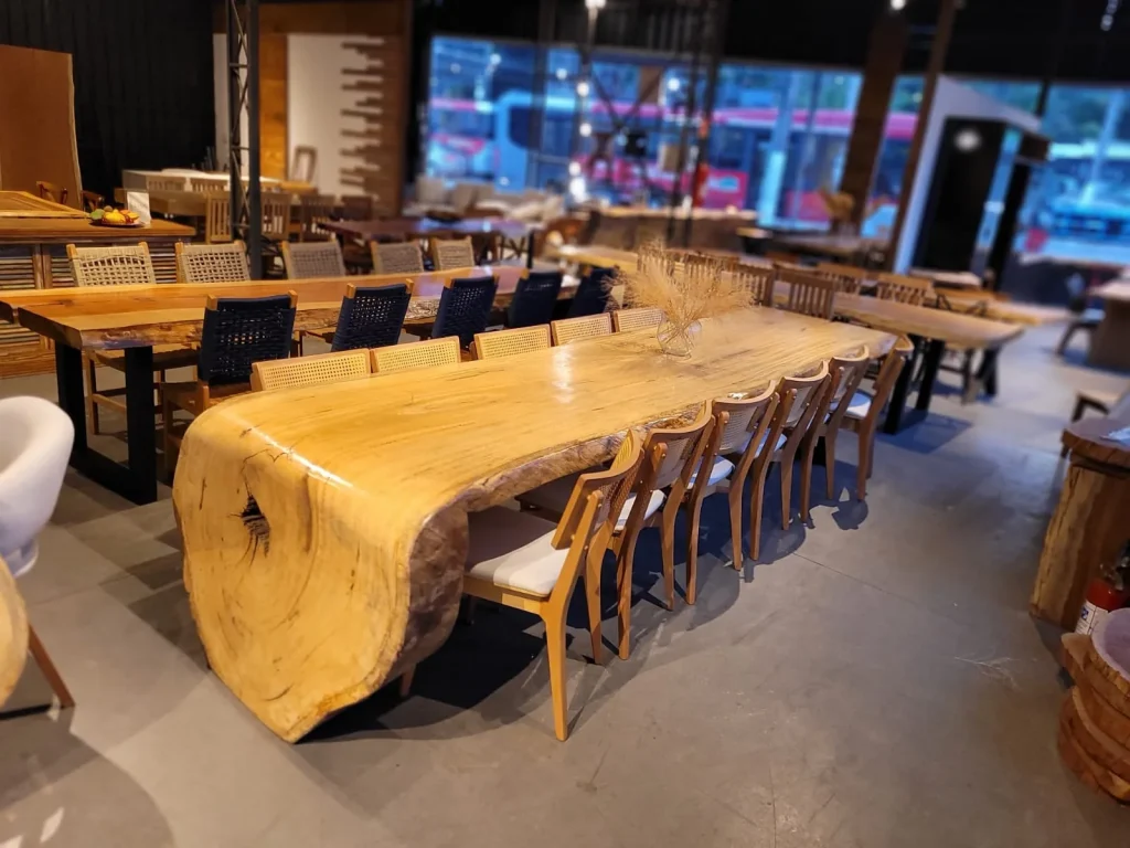 Mesa cascata de madeira maciça amarela em vista ampla do showroom, em Curitiba