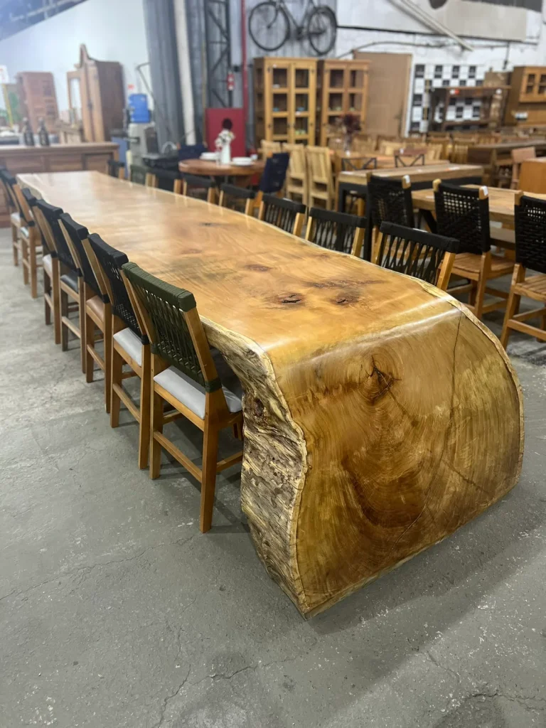 Mesa cascata de prancha maciça com cadeiras pretas no showroom de Curitiba
