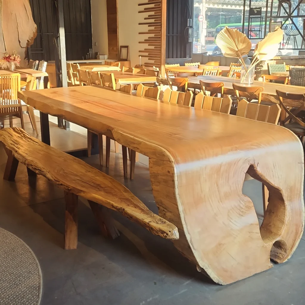 Mesa cascata com tronco vazado e banco de madeira maciça no showroom, em Curitiba